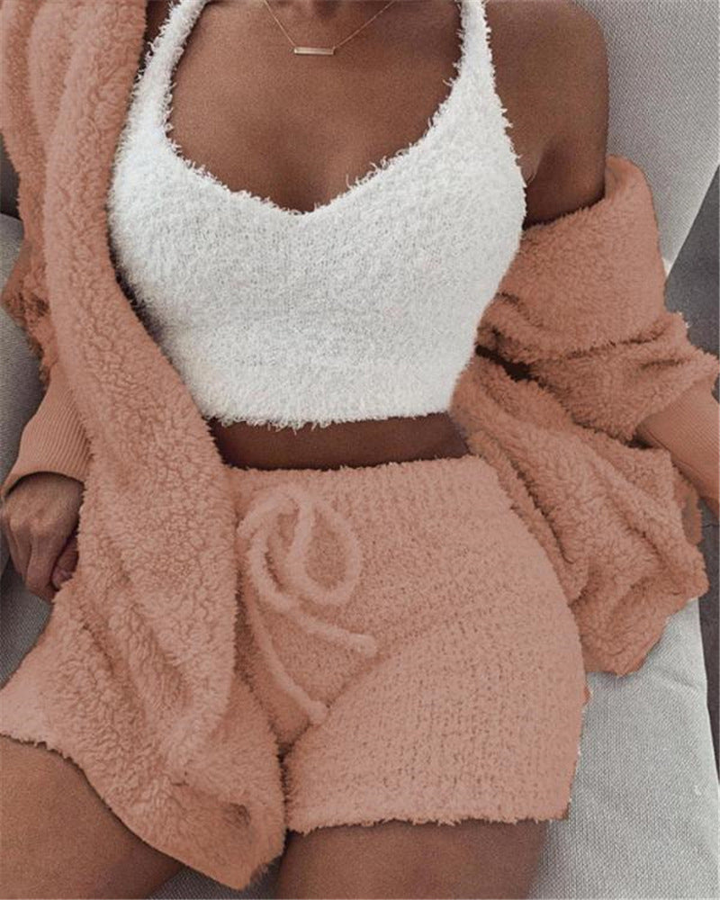 Person wearing a white fuzzy top and pink fuzzy shorts with a matching cardigan.